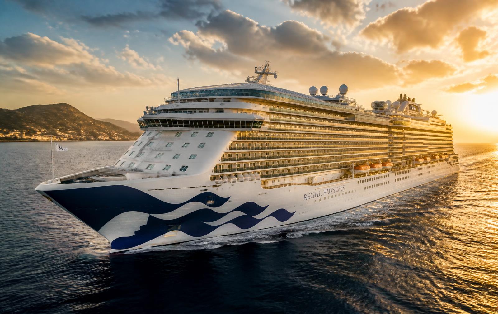 Luxury cruise ship sailing into a golden sunset